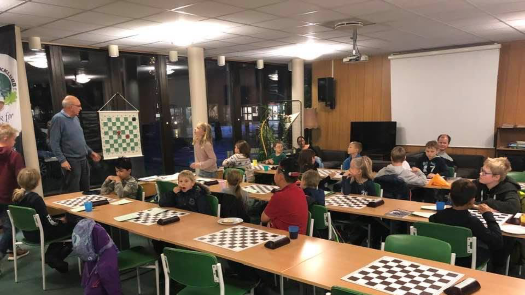 Children learning chess with a coach at Eiker Sjakklubb